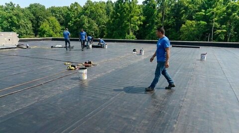 A crew welding membrane on a commercial flat roof.